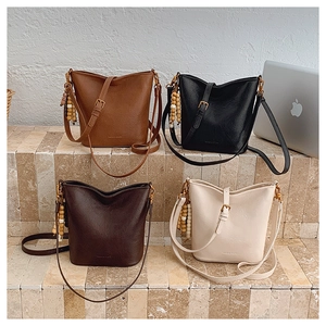 Détail de quatre sacs seaux vintage en couleurs caramel, noir, marron et blanc cassé