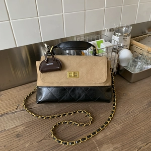 Detail of a quilted small square bag with khaki suede and black leather patchwork
