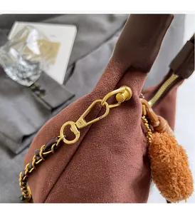 Detailed macro view of vintage brown suede handbag with luxury gold chain and hardware