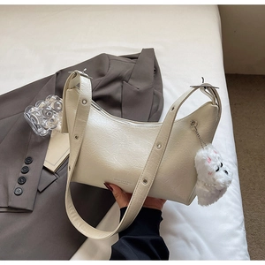 Detail of off-white shoulder bag with pleated texture and plush animal charm