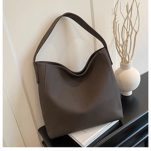 Detail of minimalist dark taupe tote bag showing premium matte leather and neat stitching