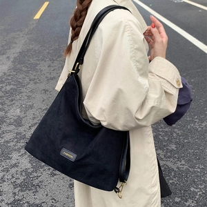Close-up of black frosted leather bucket bag with retro gold hardware and Fashion plate