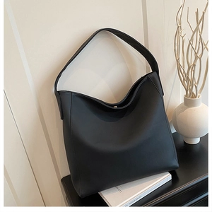 Macro view of minimalist black matte leather tote bag with sturdy magnetic closure detail
