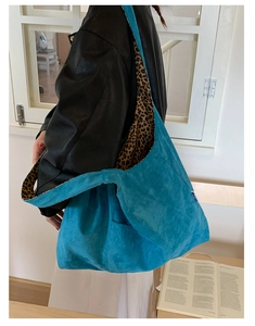 Detail of blue corduroy tote bag featuring leopard print lining and textured fabric finish