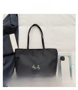 Detail view of large black tote bag showing spacious capacity for tablets and phones