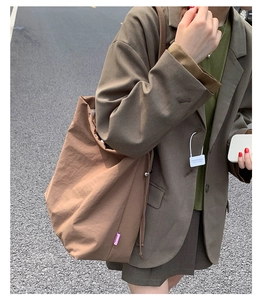 Détail d'un grand sac cabas marron avec cordon, étiquette Fashion et textile en nylon durable
