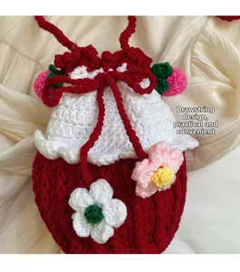 Detail of strawberry handmade crochet drawstring bucket bag with floral accents and soft texture