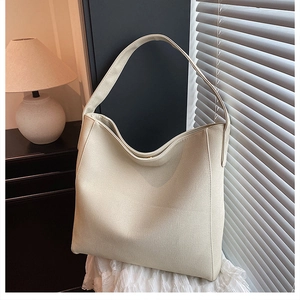 Detailed texture of off-white large capacity tote bag on lace fabric with warm lighting