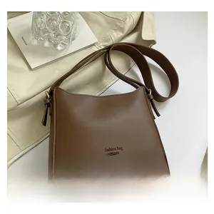 Detail view of the vintage brown leather bag with fashion text and wide strap