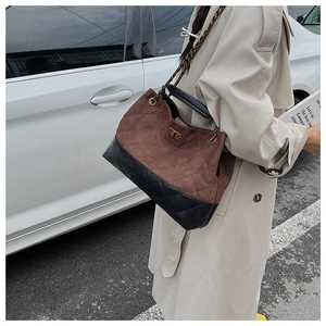 Close-up of dual-tone quilted shoulder bag with gold twist lock and chain strap detail