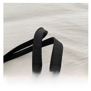 Detailed close-up of durable black canvas tote handle with reinforced stitching