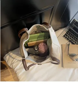 Top view of beige canvas tote bag showing large capacity with tablet, umbrella and bottle