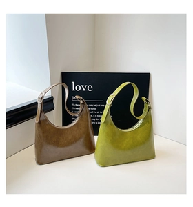 Minimalist half-moon underarm bags in glossy brown and green faux leather with silver buckles