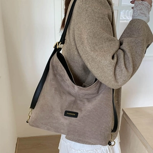 Detail of matte retro bucket bag featuring fashion label and gold metal hardware