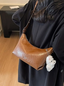 Brown vintage oil wax leather shoulder bag with plush puppy pendant and silver logo