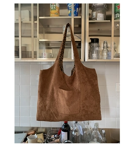 Brown faux suede tote bag featuring leopard print handles and a functional front pocket