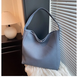 Close-up of blue lychee texture leather tote bag with magnetic metal buckle closure