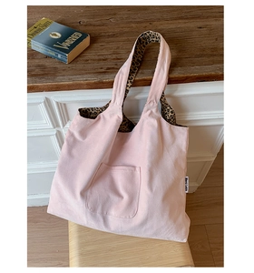 Close-up of pink canvas tote bag showing the side brand label and leopard print lining detail
