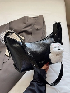 Black crescent shoulder bag with pleated leather texture and plush puppy charm