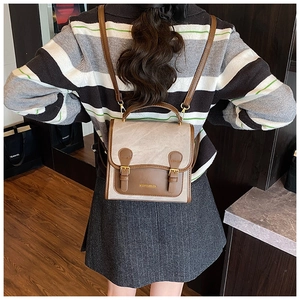 Detailed back view of a vintage faux leather backpack on model in a cozy room