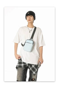 Detailansicht der hellblauen Crossbody-Brusttasche mit verstellbarem Gurt am Model
