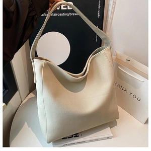 Detailed view of the creamy white faux leather tote bag with a secure metal magnetic clasp