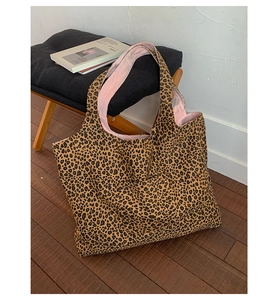 Close-up of leopard print tote bag featuring pink interior lining and functional front pocket