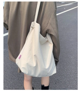 Détail de la vue arrière d'un grand sac cabas crème avec une étiquette rose tissée
