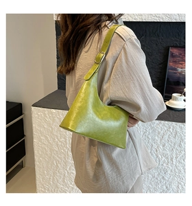 Close-up of avocado green half-moon underarm bag with retro PU leather texture and strap