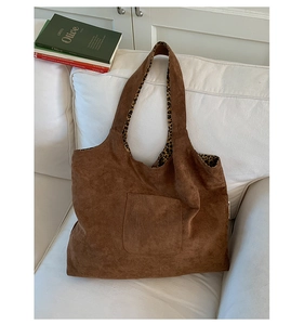 Detail view of the brown suede tote bag featuring a stylish leopard print lining