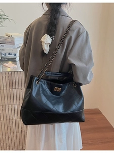 Retro black quilted leather tote bag with gold chain strap shown on a model's shoulder