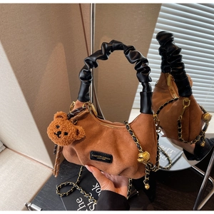 Brown suede dumpling bag featuring a black ruched handle and a cute plush bear charm