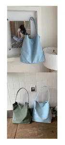 Vue détaillée des sacs cabas en toile bleu clair et vert olive dans un décor minimaliste