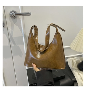 Detail of vintage brown oil wax leather hobo bag with gold adjustable buckle and zipper
