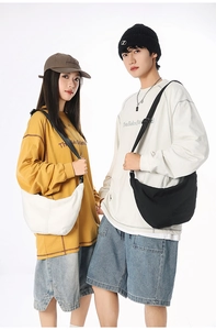 Detail of minimalist nylon crescent bags worn by couple in street style casual wear