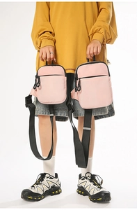 Detailansicht von zwei rosa Nylon-Umhängetaschen mit schwarzen verstellbaren Trägern