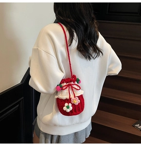 Detailed close-up of a handmade strawberry crochet bucket bag with 3D flower decorations