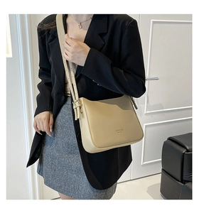 Beige crossbody bucket bag with adjustable strap shown on model in minimal urban style