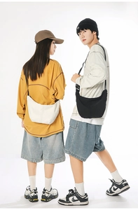 Close-up of lightweight nylon crescent bags in white and black for daily outdoor commuting