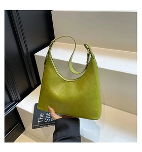 Close-up of avocado green leather shoulder bag featuring smooth textures and crescent shape