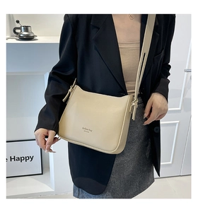 Detail of the cream leather bucket bag with fashion bag text and golden hardware