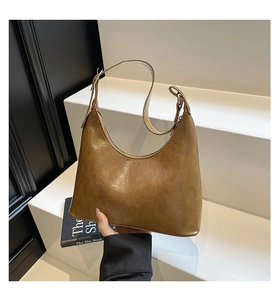 Detail of vintage brown leather hobo bag with adjustable strap and textured finish