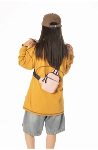 Rückansicht einer rosa Nylon-Brusttasche mit verstellbarem Gurt an einem weiblichen Model