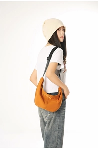 Side view of the orange nylon crescent bag worn to show size and adjustable strap