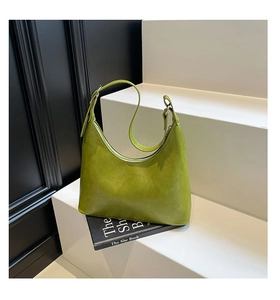Detail of vintage green hobo bag featuring glossy wax leather texture and adjustable strap