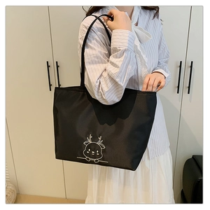 Detailed view of the cute deer embroidery on this spacious black nylon tote bag