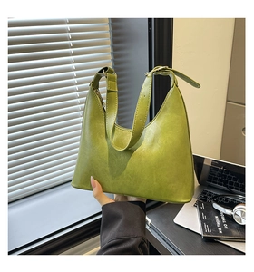 Close-up of avocado green hobo bag with adjustable strap in a modern office setting