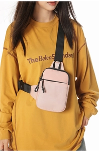 Detailaufnahme der pinken Nylon-Brusttasche mit verstellbarem Gurt und Reißverschluss