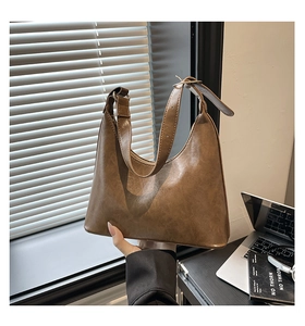 Close-up of retro dark brown hobo bag with vintage matte texture and leather strap