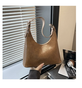 Detailed close-up of brown vintage faux leather baguette bag with adjustable strap